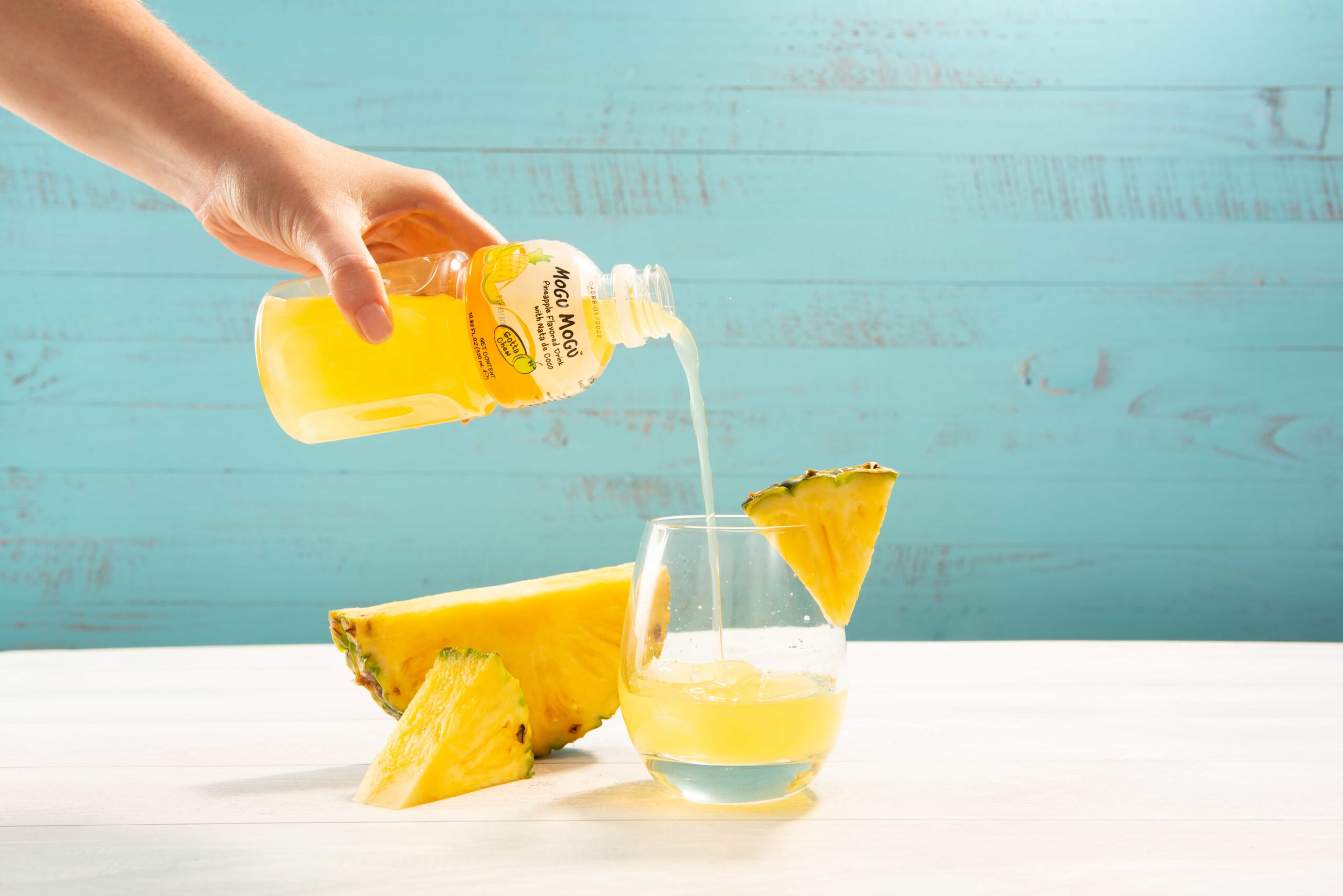 A person pouring out Mogu Mogu into a glass